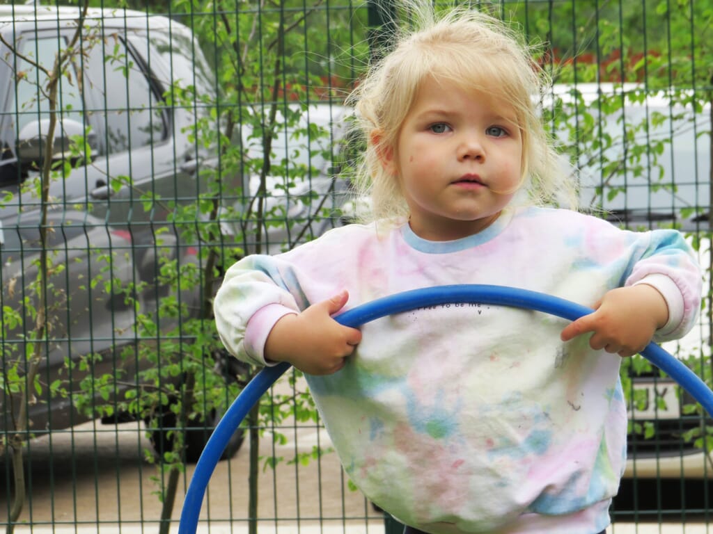 Nursery child with a hula hoop