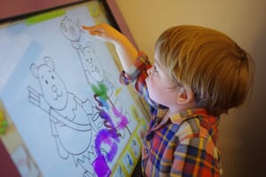 Child colouring on tablet at nursery