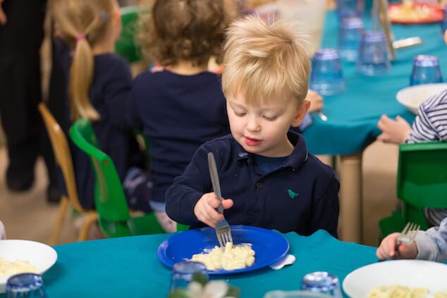 Child eating pasta at nursery