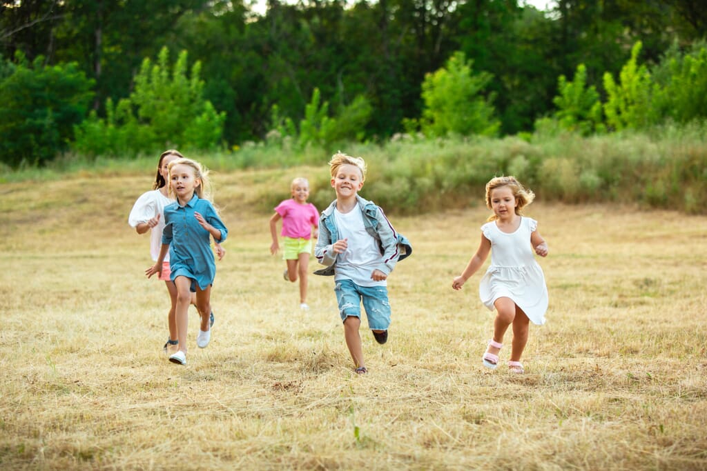 children running on meadow in summer's sunlight