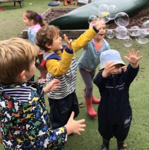 Nursery children playing with bubbles