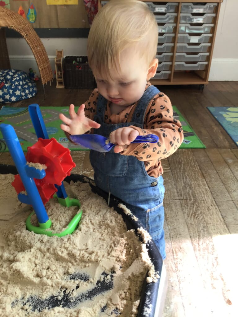 Nursery child playing with sand