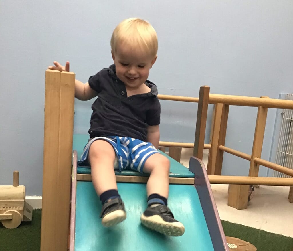 Nursery child going down slide