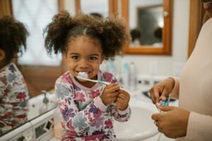 Nursery child brushing her teeth