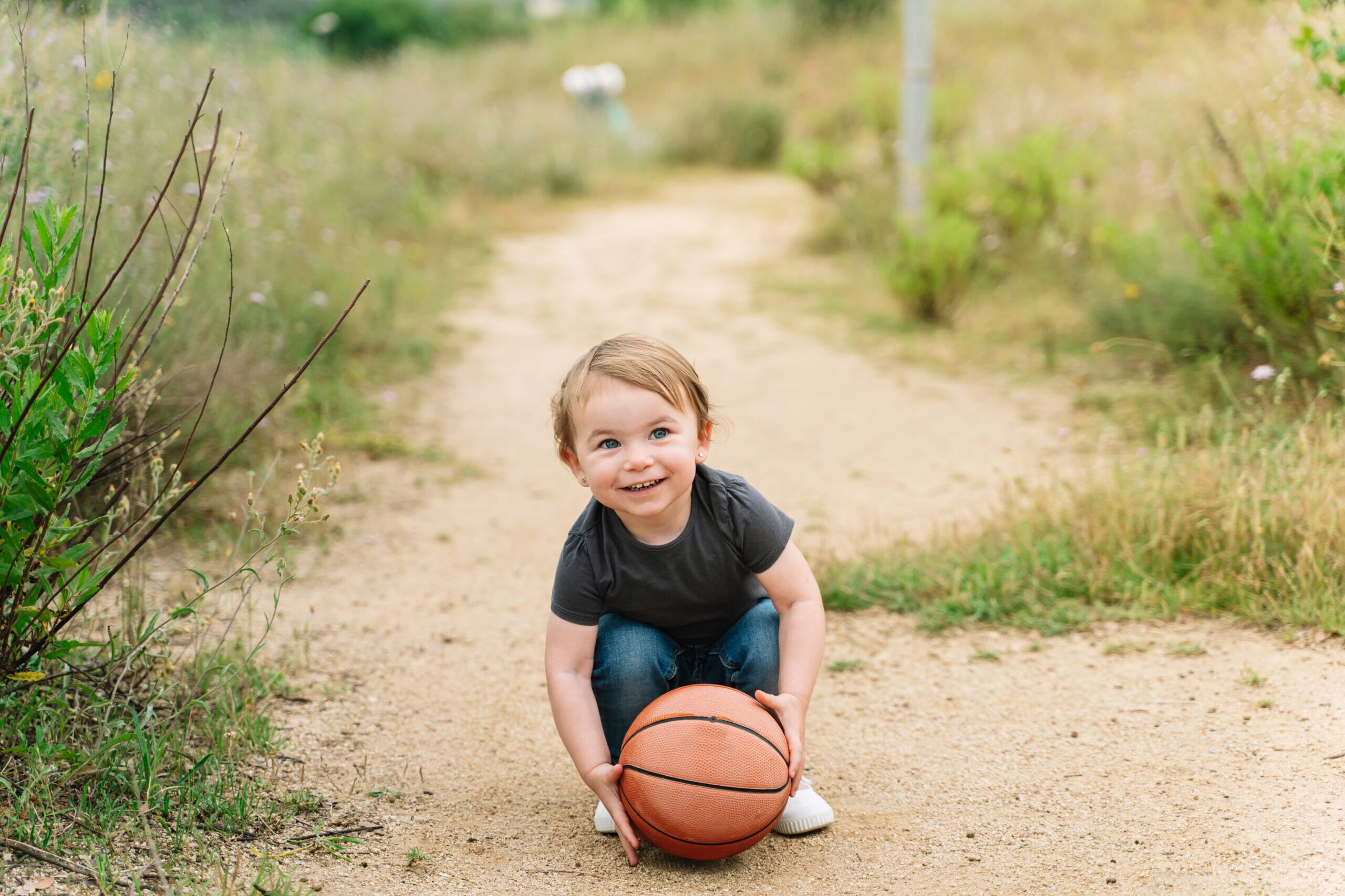 Young child holding a basketball outdoors