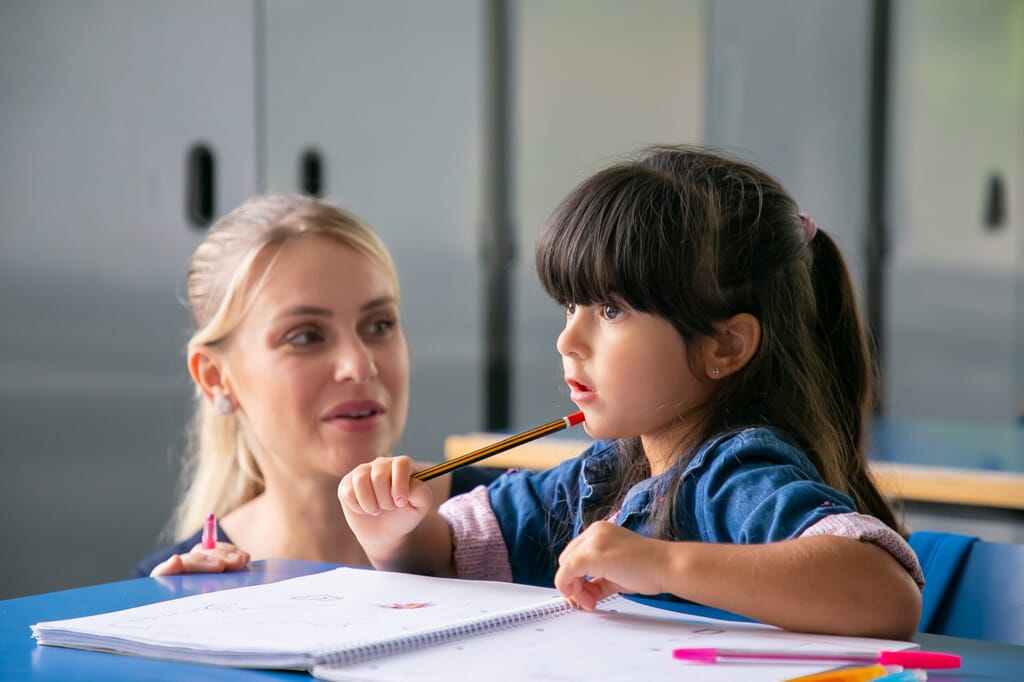 Nursery staff helping nursery child