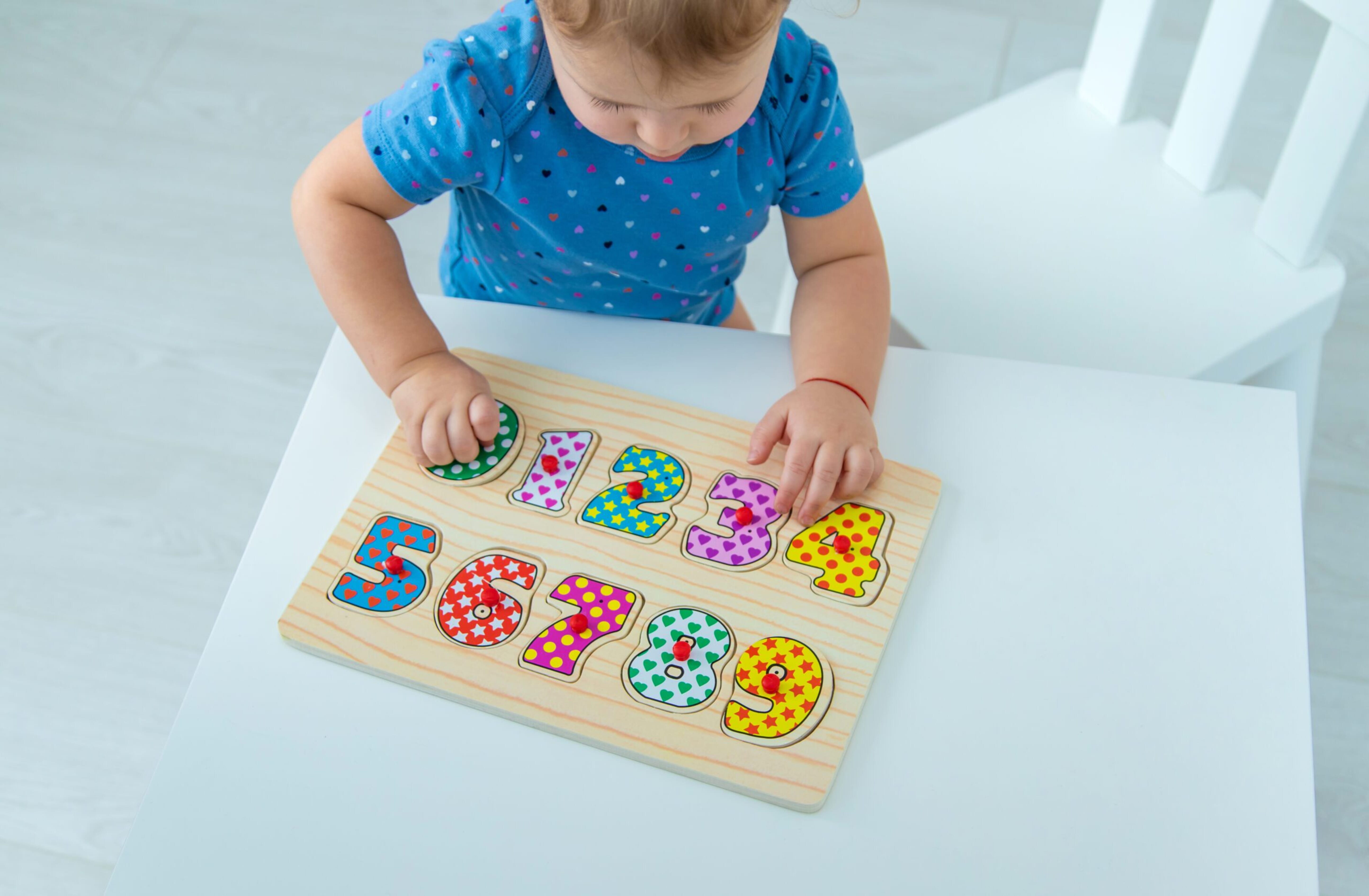 Child counting numbers on a table at home