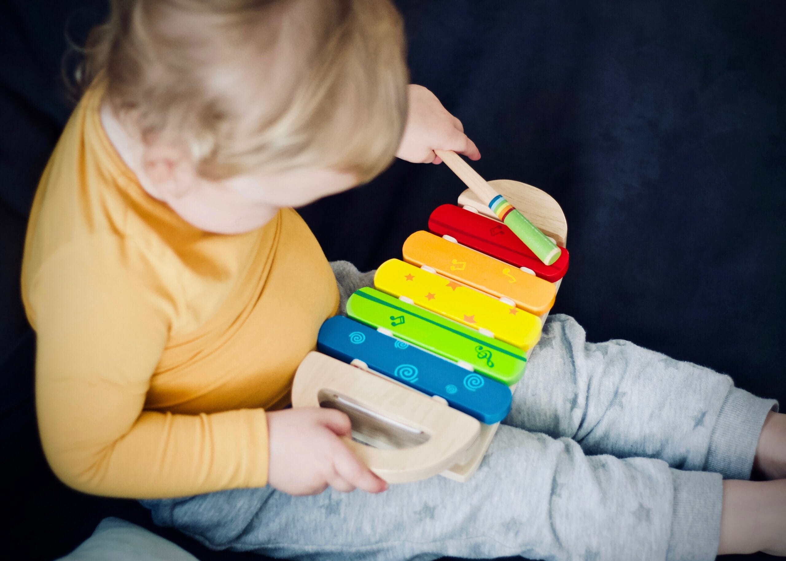 Child playing with wooden piano