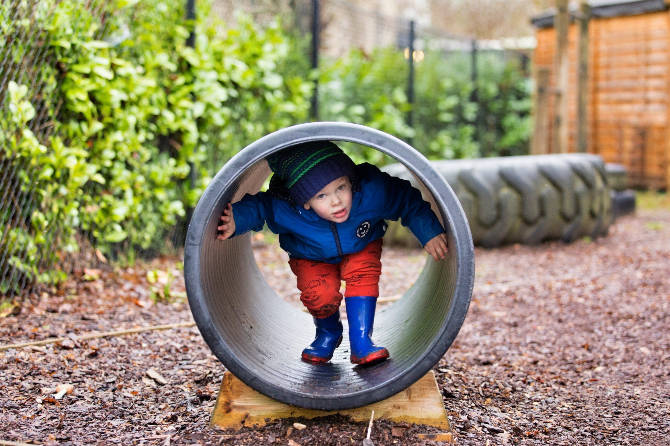 Child playing outdoors in a tunnel