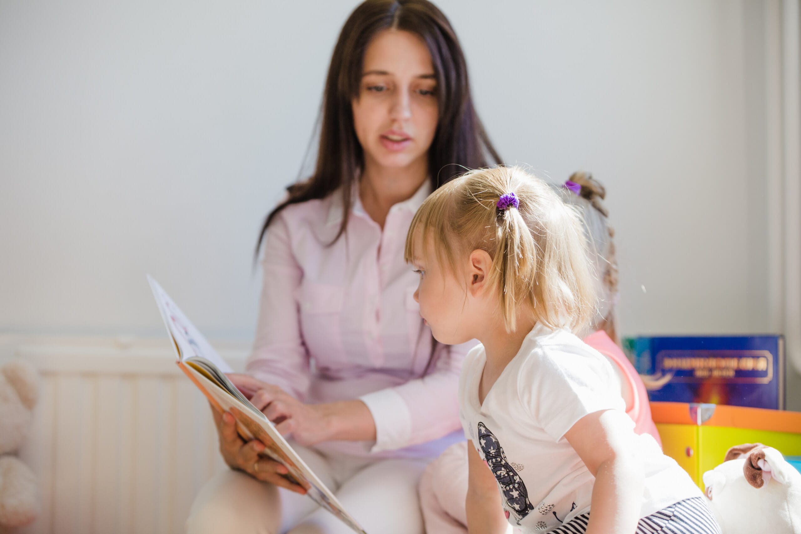 Woman showing book to child
